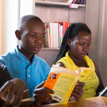 Young people and children reading books at a community library.