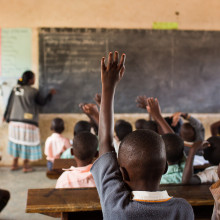 Students raising their hands at a school in Uganda.