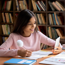 Un niño sostiene un teléfono celular viendo una clase de aprendizaje en línea para estudiar a distancia.