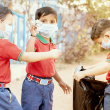 Los niños están recogiendo, limpiando basura en la escuela.