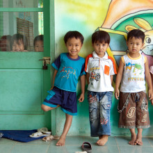 Grupo de niños pequeños de pie fuera de un aula.