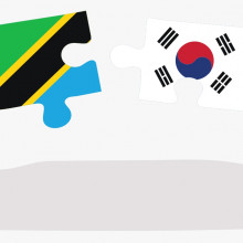 A lady holding the tanzanian flag, a man holding the korean flag