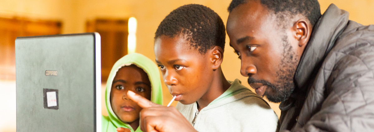 joven profesora africana involucra a los escolares en el aprendizaje en línea