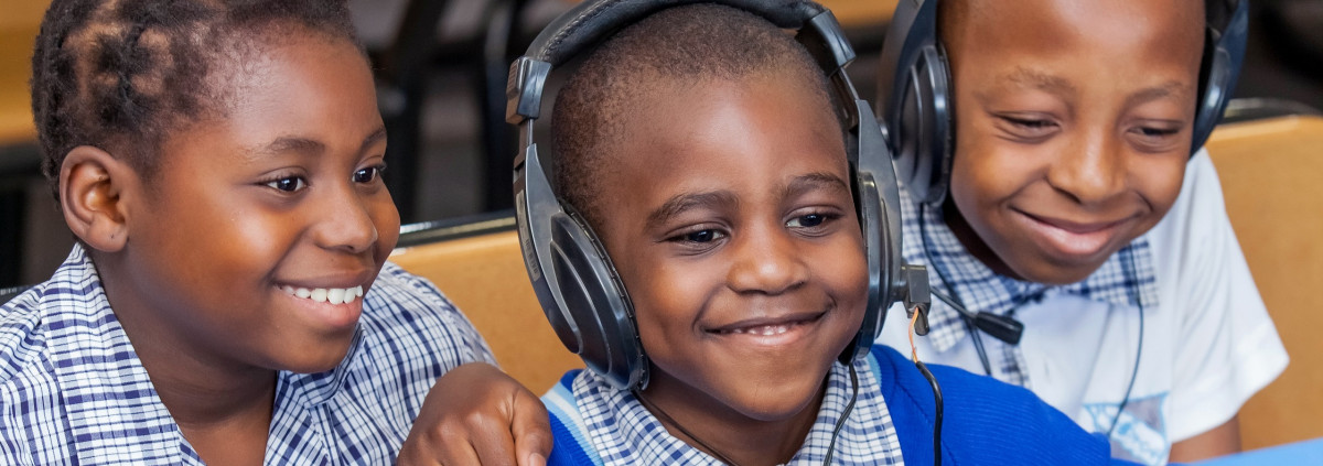 niños sonriendo mientras escuchan en los auriculares